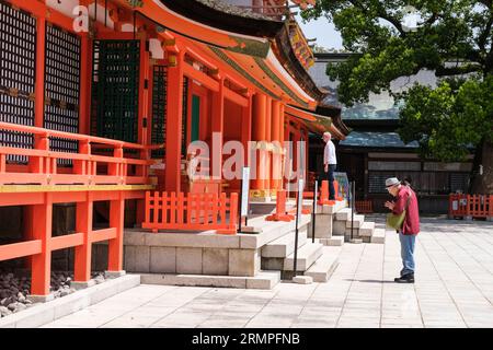 Japon, Kyushu. Adorateur priant au sanctuaire shinto Jingu des États-Unis, le plus important sanctuaire shinto du Japon. Banque D'Images