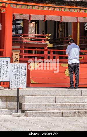 Japon, Kyushu. Adorateur priant au sanctuaire shinto Jingu des États-Unis, le plus important sanctuaire shinto du Japon. Banque D'Images