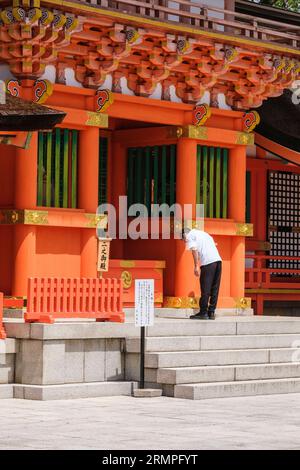 Japon, Kyushu. Adorateur priant au sanctuaire shinto Jingu des États-Unis, le plus important sanctuaire shinto du Japon. Banque D'Images