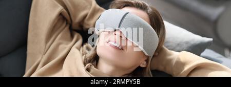 Une femme endormi dans un masque sourit dans un rêve, un gros plan Banque D'Images