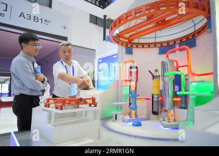 YANTAI, CHINE - 29 AOÛT 2023 - les visiteurs découvrent le modèle de l'unité nucléaire Hualong One au salon Green, Low-carbon and High Quality de 2023 Banque D'Images