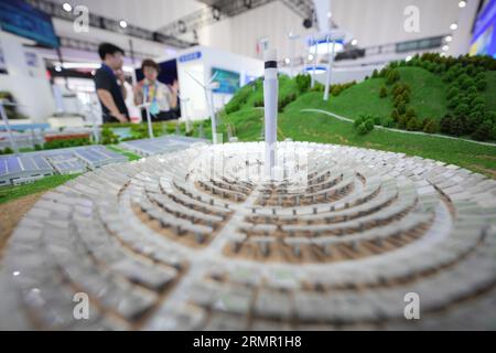 YANTAI, CHINE - le 29 AOÛT 2023 - les visiteurs examinent des modèles de systèmes d'énergie renouvelable lors du Confe 2023 sur le développement vert, à faible émission de carbone et de haute qualité Banque D'Images