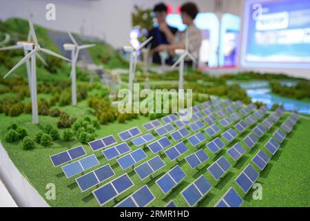YANTAI, CHINE - le 29 AOÛT 2023 - les visiteurs examinent des modèles de systèmes d'énergie renouvelable lors du Confe 2023 sur le développement vert, à faible émission de carbone et de haute qualité Banque D'Images