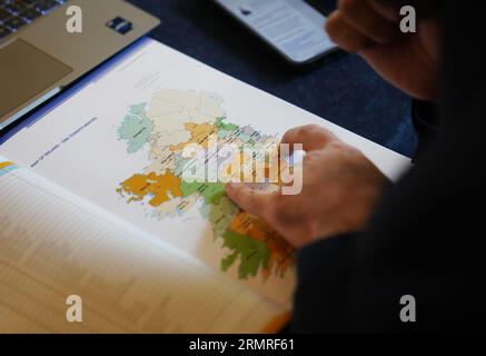 Un journaliste regarde une carte de l'Irlande montrant les circonscriptions de Dail lors d'une conférence de presse au Royal College of Physicians, Dublin, pour l'annonce par la commission électorale des nouvelles circonscriptions tant attendues pour l'Irlande, qui a recommandé le nombre de TDS augmenter de 160 à 174 en raison des règles constitutionnelles liées à une augmentation de la population, et le nombre de circonscriptions augmenter de 39 à 43. Date de la photo : mercredi 30 août 2023. Banque D'Images