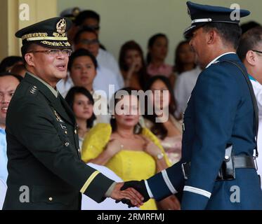 (140718) -- La ville de Quezon, Le 18 juillet 2014 (Xinhua) -- les Forces armées des Philippines (AFP) Chef de cabinet le général Gregorio Pio Catapang, Jr., (L'avant), serre la main avec un officier militaire durant les rites d'AFP Changement de commande à l'intérieur camp Aguinaldo à Quezon City, aux Philippines le 18 juillet 2014. Le président philippin Benigno Aquino III a nommé Lieutenant général Gregorio Pio Catapang, Jr. en tant que nouveau chef d'état-major des Forces armées des Philippines (AFP) l'AFP , a déclaré mercredi. Catapang a officiellement pris ses fonctions en tant que 45e Chef du personnel de l'AFP le vendredi Banque D'Images