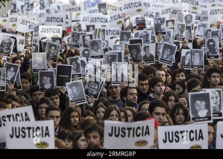 Les résidents tiennent des portraits de victimes lors d’un rassemblement pour commémorer le 20e anniversaire de l’attaque terroriste contre l’Association mutuelle israélite Argentine (AMIA, pour son acronyme en espagnol), à Buenos Aires, capitale de l’Argentine, le 18 juillet 2014. La commémoration a commencé à 9:53 heures du matin, exactement au même moment que l'explosion à l'entrée du bâtiment de l'AMIA s'est produite le 18 juillet 1994, faisant 85 morts et plus de 300 blessés. (Xinhua/Martin Zabala) (vf) (fnc) ARGENTINA-BUENOS AIRES-SOCIETY-ANNIVERSARY PUBLICATIONxNOTxINxCHN Banque D'Images