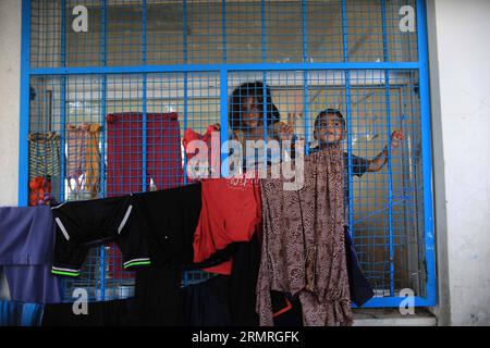 Des enfants palestiniens qui ont fui leur maison adjacente à la frontière avec Israël sont vus depuis une fenêtre dans une école gérée par les Nations Unies dans la ville de Gaza le 18 juillet 2014. Environ 300 Palestiniens ont été tués et 2 100 blessés dans l'offensive de grande envergure de l'armée israélienne sur la bande de Gaza qui a commencé le 8 juillet, ont déclaré les responsables tôt samedi. (Xinhua/Wissam Nassar) (zjy) MIDEAST-GAZA-AIRSTRIKE PUBLICATIONxNOTxINxCHN PALESTINIENS enfants qui de chez eux Thatcher EST adjacent à la frontière avec Israël sont des lacs de fenêtres DANS une école des Nations Unies à Gaza juillet 18 20 Banque D'Images