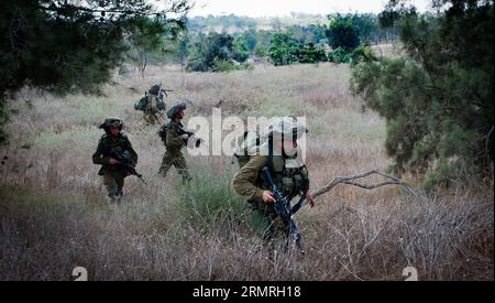 Des soldats de combat israéliens avancent dans le sud d’Israël près de la frontière avec Gaza, le 12e jour de l’opération bordure protectrice, le 19 juillet 2014. Deux soldats israéliens ont été tués dans un échange de tirs avec des militants palestiniens qui ont infiltré le territoire israélien à travers un tunnel de Gaza samedi, ont confirmé les Forces de défense israéliennes (FDI) dans un communiqué. (Xinhua/JINI) ISRAËL-GAZA-FRONTIÈRE-SOLDATS ISRAÉLIENS TUÉS PUBLICATIONxNOTxINxCHN les soldats de combat israéliens avancent dans le sud d'Israël près de la frontière avec Gaza LE 12e jour de l'opération bordure protectrice LE 19 2014 juillet deux soldats israéliens étaient KIL Banque D'Images