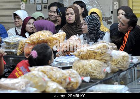 (140721) -- JAKARTA, 21 juillet 2014 (Xinhua) -- les clients choisissent des biscuits et des collations traditionnels pour le prochain festival Eid al-Fitr sur un marché à Jakarta, Indonésie, le 21 juillet 2014. Traditionnellement, les gens rendent visite à leurs parents et amis et profitent de divertissements en plein air pendant l'Aïd al-Fitr qui marque la fin du mois sacré du Ramadan. (Xinhua/Agung Kuncahya B.)(cy) INDONESIA-JAKARTA-EID AL-FITR-PREPARATION PUBLICATIONxNOTxINxCHN Jakarta juillet 21 2014 clients de XINHUA sélectionnez des biscuits traditionnels et des collations pour le prochain festival Oath Al Fitr À un marché à Jakarta Indonésie juillet 21 2014 Cele Banque D'Images