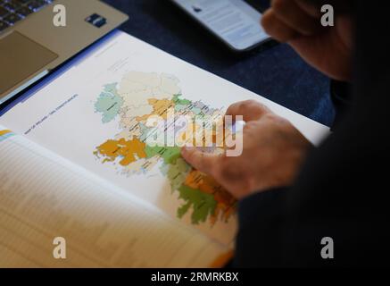 Un journaliste regarde une carte de l'Irlande montrant les circonscriptions de Dail lors d'une conférence de presse au Royal College of Physicians, Dublin, pour l'annonce par la commission électorale des nouvelles circonscriptions tant attendues pour l'Irlande, qui a recommandé le nombre de TDS augmenter de 160 à 174 en raison des règles constitutionnelles liées à une augmentation de la population, et le nombre de circonscriptions augmenter de 39 à 43. Date de la photo : mercredi 30 août 2023. Banque D'Images