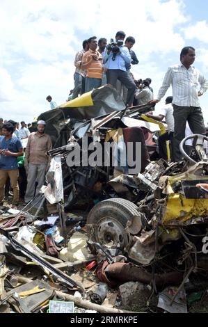 (140725) -- HYDERABAD, 25 juillet 2014 (Xinhua) -- des gens se rassemblent sur le site d'un accident de la circulation à Masayapeta près d'Hyderabad, capitale de l'État de Telangana, dans le sud de l'Inde, le 24 juillet 2014. Au moins 20 élèves et leur chauffeur d'autobus scolaire ont été tués tandis que 20 autres élèves ont été blessés après qu'un train à grande vitesse a percuté le bus à un passage sans pilote jeudi, a déclaré un responsable de la police. (Xinhua/Stringer) (FOCUS)INDE-HYDERABAD-ACCIDENT DE LA CIRCULATION PUBLICATIONxNOTxINxCHN Hyderabad juillet 25 2014 des célébrités XINHUA se rassemblent SUR le site de l'accident de la circulation près de Hyderabad capitale de l'État de tel du sud de l'Inde Banque D'Images