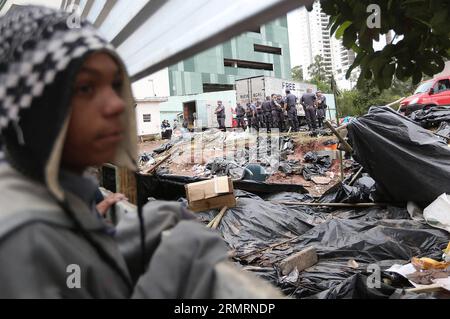 (140728) -- SAO PAULO, 28 juillet 2014 (Xinhua) -- Un enfant regarde des policiers expulser des sans-abri d'un terrain privé près du stade Arena de Sao Paulo, qui a été occupée par 4 000 familles pauvres depuis le tournoi de la coupe du monde de la FIFA en juin dans le cadre de la coupe du peuple , une campagne pour les droits des pauvres au Brésil organisée par le mouvement des travailleurs sans abri, à Sao Paulo, la plus grande ville du Brésil, le 28 juillet 2014. (Xinhua/Rahel Patrasso) BRÉSIL-SAO PAULO-SOCIÉTÉ-SANS-ABRI-EXPULSION PUBLICATIONxNOTxINxCHN Sao Paulo juillet 28 2014 XINHUA un enfant regarde comme policiers Evict Home célébrités FR Banque D'Images