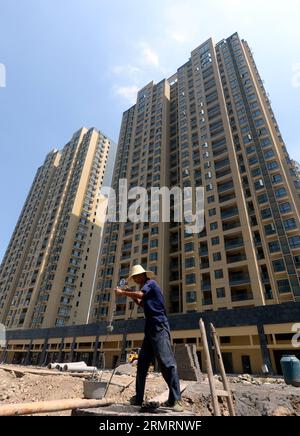 (140729) -- HANGZHOU, 29 juillet 2014 (Xinhua) -- Un ouvrier travaille sur un chantier de construction dans le district de Xiaoshan, Hangzhou, capitale de la province du Zhejiang de l'est de la Chine, 29 juillet 2014. Hangzhou va lever l’interdiction d’acheter une résidence secondaire dans les districts de Xiaoshan et Yuhang à partir de mardi, selon le Bureau de la sécurité et de la gestion du logement de Hangzhou. L’interdiction est également levée pour les acheteurs achetant une maison de plus de 140 mètres carrés dans les zones du centre-ville, selon le bureau. Jusqu’à présent, environ 20 régions, principalement des villes de deuxième et troisième rang où les stocks sont élevés, ont levé ou assoupli les interdictions de propriété de m Banque D'Images
