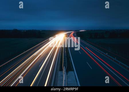 Autoroute animée dans la campagne la nuit. Thèmes transport en voiture, direction et connexion. Banque D'Images