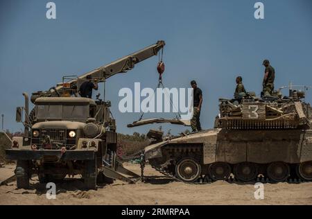 FRONTIÈRE DE GAZA, le 30 juillet 2014 -- le blindage d'un APC israélien est hissé pour réparation dans une zone de déploiement de l'armée dans le sud d'Israël près de la frontière avec Gaza, le 30 juillet 2014. Trois soldats israéliens ont été tués dans la bande de Gaza mercredi, a déclaré le porte-parole des Forces de défense israéliennes (FDI) dans un communiqué. ISRAËL-GAZA-FRONTIÈRE-COMBATS-TROIS SOLDATS ISRAÉLIENS-TUÉS lixrui PUBLICATIONxNOTxINxCHN frontière de Gaza juillet 30 2014 l'armure de à l'APC israélien EST hissée pour réparation DANS la zone de l'armée dans le sud d'Israël près de la frontière avec Gaza LE 30 2014 juillet, trois soldats israéliens ont été TUÉS à Th Banque D'Images