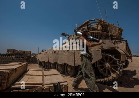 FRONTIÈRE DE GAZA, le 30 juillet 2014 -- un soldat israélien porte un obus sur une zone de déploiement de l'armée dans le sud d'Israël près de la frontière avec Gaza, le 30 juillet 2014. Trois soldats israéliens ont été tués dans la bande de Gaza mercredi, a déclaré le porte-parole des Forces de défense israéliennes (FDI) dans un communiqué. ISRAËL-GAZA-FRONTIÈRE-COMBATS-TROIS SOLDATS ISRAÉLIENS-TUÉS lixrui PUBLICATIONxNOTxINxCHN frontière de Gaza juillet 30 2014 à un soldat israélien porte un obus À LA zone de l'armée dans le sud d'Israël près de la frontière avec Gaza LE 30 2014 juillet trois soldats israéliens ont été TUÉS dans la bande de Gaza mercredi l'Israël Banque D'Images