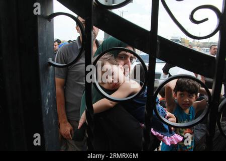 (140805) -- GAZA, 5 août 2014 -- les Palestiniens qui espèrent traverser en Égypte attendent au point de passage de Rafah entre l'Égypte et le sud de la bande de Gaza, 5 août 2014. La proposition égyptienne de cessez-le-feu a été approuvée lundi par les Palestiniens et tard dans la nuit a également été acceptée par le Premier ministre israélien Benjamin Netanyahu, apportant une pause très attendue au conflit meurtrier de 29 jours. MIDEAST-GAZA-RAFAH-POINT DE PASSAGE KhaledxOmar PUBLICATIONxNOTxINxCHN Gaza août 5 2014 PALESTINIENS qui espèrent passer en Egypte attendent AU point de passage de Rafah entre l'Egypte et le sud de la bande de Gaza août 5 2014 T. Banque D'Images