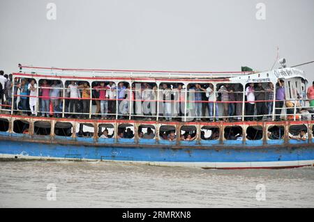 (140806) -- MAWA, 6 août 2014 -- des Bangladais surveillent l'opération de sauvetage pendant que l'équipe de sauveteurs continue de fouiller l'endroit dans l'eau deux jours après l'accident du ferry sur la rivière Padma dans le district de Munshiganj, à environ 37 km de la capitale Dhaka, Bangladesh, 6 août 2014. Le nombre de morts du capsizal de ferry lundi dans le district central de Munshiganj du Bangladesh a augmenté à 11 mercredi matin après que sept autres corps ont été récupérés loin du site où le navire a coulé avec quelque 250 passagers à bord, a déclaré la police. (Lmz) BANGLADESH-DHAKA-FERRY-ACCIDENT SharifulxIslam PUB Banque D'Images