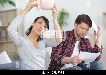 couple essayant de casser la tirelire Banque D'Images