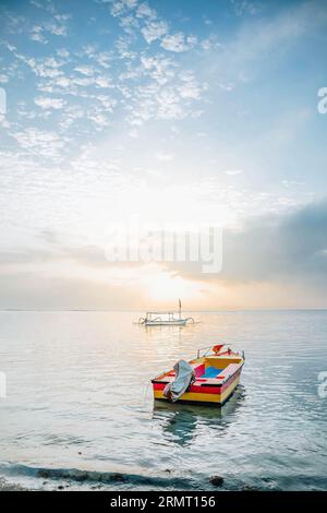 Un bateau traditionnel coloré en bois flottant sur la plage le matin Banque D'Images