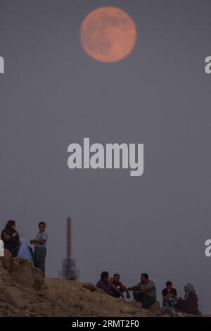 (140810) -- LE CAIRE, 10 août 2014 -- les Égyptiens parlent au sommet d'une colline quand la superlune se lève au Caire, en Égypte, le 10 août 2014. La superlune, techniquement connue sous le nom de lune périgée, apparaît lorsque la lune est la plus proche de la Terre dans son orbite, ce qui la rend beaucoup plus grande et plus lumineuse que d'habitude. EGYPT-CAIRO-SUPERMOON PanxChaoyue PUBLICATIONxNOTxINxCHN le Caire août 10 2014 les Égyptiens parlent au sommet d'une colline quand la Super Lune se lève au Caire Egypte LE 10 2014 août la Super Lune techniquement connue sous le nom de Perigee Moon apparaît quand la Lune EST dans son orbite la plus proche de la Terre, la faisant apparaître beaucoup grand Banque D'Images