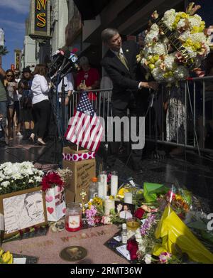 (140812) -- LOS ANGELES, 12 août 2014 -- Leron Gubler (devant), président-directeur général de la Chambre de commerce d'Hollywood, présente une couronne de fleurs à l'étoile Robin Williams sur le Hollywood Walk of Fame à Hollywood, Californie, États-Unis, le 12 août 2014. Le comédien américain Robin Williams, lauréat d'un Oscar, est mort d'un suicide apparent lundi dans sa maison du nord de la Californie. US-LOS ANGELES-ROBIN WILLIAMS-DEATH YangxLei PUBLICATIONxNOTxINxCHN Los Angeles août 12 2014 Leron Gubler Front Président et PDG de la Chambre de Commerce d'Hollywood présente une fleur À Robin Williams Star ON the Holly Banque D'Images