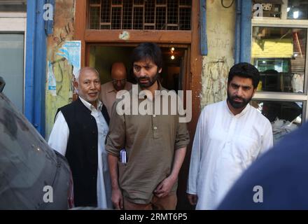 (140819) -- SRINAGAR, 19 août 2014 -- le président du groupe pro-indépendant Jammu Kashmir Liberation Front (JKLF) Yasin Malik (C) part rencontrer le haut-commissaire du Pakistan à New Delhi Abdul Basit à Srinagar, capitale d'été du Cachemire contrôlé par l'Inde, le 19 août 2014. Lundi, les dirigeants séparatistes cachemiriens ont critiqué New Delhi pour avoir annulé les pourparlers au niveau des ministres des Affaires étrangères avec Islamabad et ont qualifié la décision de regrettable. L'Inde a annulé lundi les pourparlers au niveau des ministres des Affaires étrangères avec le Pakistan qui devaient se tenir à Islamabad le 25 août. )(zhf) CACHEMIRE-SRINAGAR-SÉPARATISTE JavedxDar PUBLIC Banque D'Images