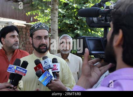 (140819) -- SRINAGAR, 19 août 2014 -- le président de la faction modérée de la Conférence Hurriyat (liberté) Mirwaiz Umar Farooq (2e, gauche) s'adresse aux médias avant de partir rencontrer le haut-commissaire du Pakistan à New Delhi Abdul Basit à Srinagar, capitale estivale du Cachemire contrôlé par l'Inde, le 19 août 2014. Lundi, les dirigeants séparatistes cachemiriens ont critiqué New Delhi pour avoir annulé les pourparlers au niveau des ministres des Affaires étrangères avec Islamabad et ont qualifié la décision de regrettable. L'Inde a annulé lundi les pourparlers au niveau des ministres des Affaires étrangères avec le Pakistan qui devaient se tenir à Islamabad le 25 août. )(zhf) CACHEMIRE-SRINAGAR- Banque D'Images