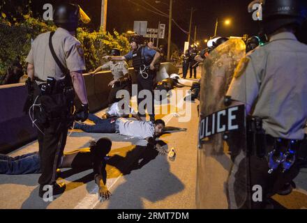 Des policiers arrêtent des manifestants lors d’une manifestation contre le meurtre par la police de Michael Brown, 18 ans, et d’un autre homme noir de 23 ans à Ferguson, Missouri, États-Unis, le 19 août 2014. Un homme de 23 ans a été tué par balle après avoir brandi un couteau sur des policiers dans le nord de St. Louis mardi, les autorités locales ont dit. ) (Dzl) US-MISSOURI-FERGUSON-PROTEST-CLASH TingxShen PUBLICATIONxNOTxINxCHN des policiers arrêtent un manifestant lors d'une manifestation contre le meurtre par la police de Michael Brown, âgé de 18 ans, et d'un autre Noir de 23 ans à Ferguson Missouri aux États-Unis O Banque D'Images