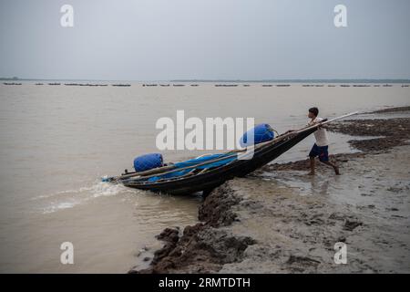 26 août 2023, Khulna, Bangladesh : un pêcheur est vu en train de pêcher sur la rivière Shibsha. Il n'y a pas si longtemps, Kalabogi, un village côtier du Bangladesh, était plein de terres cultivables jusqu'à ce que la montée du niveau de la mer commence à envahir la région jusqu'au golfe du Bengale. De fréquents cyclones et inondations frappent le village depuis la fin des années 1990 En 2009, un cyclone majeur nommé Aila a détruit les 1 400 kilomètres de remblais du pays, 8 800 kilomètres de routes et environ 3 50 000 acres de terres agricoles. Plusieurs centaines de personnes auraient été tuées dans la catastrophe. Les agriculteurs de Kalabogi étaient le W. Banque D'Images