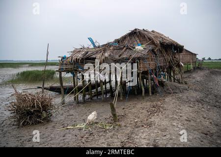 Le 26 août 2023, Khulna, Bangladesh : des maisons sont partiellement endommagées après une forte tempête dans une zone côtière à Kalabogi dans la province de Khulna. Il n'y a pas si longtemps, Kalabogi, un village côtier du Bangladesh, était plein de terres cultivables jusqu'à ce que la montée du niveau de la mer commence à envahir la région jusqu'au golfe du Bengale. De fréquents cyclones et inondations frappent le village depuis la fin des années 1990 En 2009, un cyclone majeur nommé Aila a détruit les 1 400 kilomètres de remblais, 8 800 kilomètres de routes et environ 3,50,000 acres de terres agricoles. Plusieurs centaines de personnes auraient été tuées au cours de la distille Banque D'Images