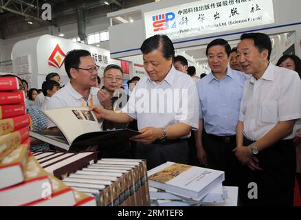 (140831) -- BEIJING, 31 août 2014 -- Liu Yunshan (C), membre du comité permanent du bureau politique du comité central du Parti communiste chinois, lit un album photo en langue étrangère lors d'une visite à la Foire internationale du livre de Beijing, Chine, le 31 août 2014.) (hdt) CHINA-BEIJING-BIBF-LIU YUNSHAN-VISIT (CN) LiuxWeibing PUBLICATIONxNOTxINxCHN Beijing août 31 2014 Liu Yunshan C un membre du Comité politique du Parti communiste de Chine lit un album de photos en langue étrangère lors d'une visite à la Foire internationale du livre de Beijing C Banque D'Images