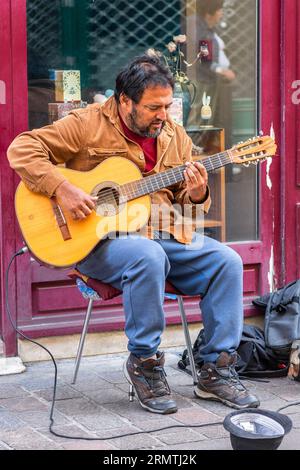 Homme espagnol jouant de la guitare pour de l'argent dans la rue de la ville - Tours, Indre-et-Loire (37), France. Banque D'Images