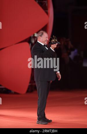 Le réalisateur Roy Andersson pose avec le Lion d'or pour le meilleur film qu'il a reçu pour son film A Pigeon Sat on a Branch reflétant l'existence lors de la cérémonie de remise des prix au 71e Festival du film de Venise, au Lido de Venise, Italie, le 6 septembre 2014. Le film suédois a remporté le Lion d'or du meilleur film, le plus grand prix décerné au 71e festival du film de Venise qui s'est terminé ici samedi. ) ITALIE-VENISE-FILM FESTIVAL-LION D'OR LiuxLihang PUBLICATIONxNOTxINxCHN le réalisateur Roy Andersson pose avec le Lion d'Or pour le meilleur film qu'il a reçu pour son film a Pigeon SAT ON a Branch Reflecting ON existence During T. Banque D'Images