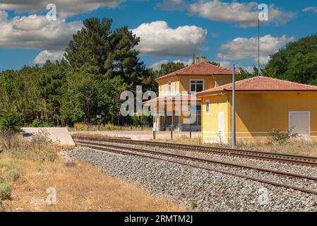 image conceptuelle de voyage avec des voies de train au premier plan et une gare vide floue en arrière-plan Banque D'Images