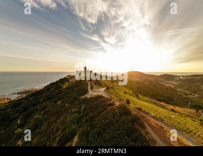 Vue aérienne de la pittoresque ville côtière de Collioure au lever du soleil, mettant en valeur le majestueux fort Saint Elme en arrière-plan Banque D'Images