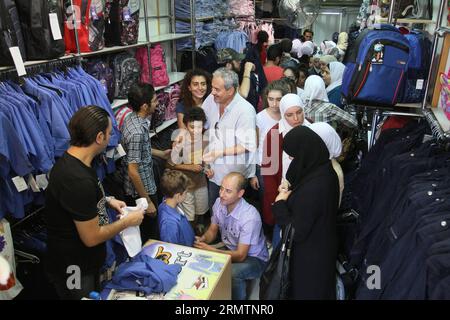 (140913) -- DAMAS, 13 septembre 2014 -- des élèves syriens achètent des uniformes scolaires à Damas, en Syrie, le 13 septembre 2014, un jour avant le début de la nouvelle année scolaire dans ce pays déchiré par la guerre. Quelque 4,5 millions d’élèves syriens iront à leurs écoles le 14 septembre, malgré l'autorisation du président américain Barack Obama de frappes aériennes américaines en Syrie contre les États islamiques (EI).)(zhf) SYRIE-DAMAS-NOUVELLE ANNÉE SCOLAIRE bassemxtellawi PUBLICATIONxNOTxINxCHN Damas Sep 13 2014 étudiants syriens achètent DES UNIFORMES scolaires à Damas Syrie LE 13 2014 septembre un jour avant le début de la nouvelle année scolaire dans ceci Banque D'Images