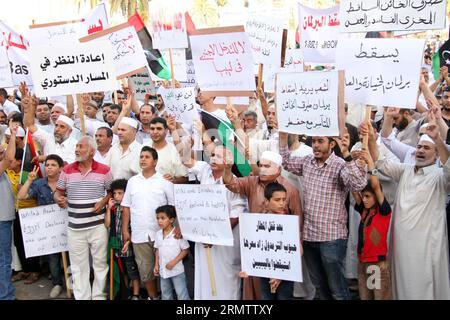 (140919) -- TRIPOLI, 19 septembre -- des manifestants brandissent des pancartes et chantent des slogans lors d'un rassemblement sur la place des martyrs à Tripoli, en Libye, le 19 septembre 2014. Des centaines de personnes sont descendues dans la rue à Tripoli pour montrer leur soutien au Premier ministre soutenu par les islamistes Omar al-Hasi. Depuis juillet, la Libye jongle avec deux gouvernements rivaux, l'un dirigé par l'islamiste Hasi et l'autre dirigé par le pro-laïque Abdullah al-Thinni, qui est maintenant en exil dans la ville de Tobrouk, dans l'est de la Libye. LIBYE-TRIPOLI-HASI-RALLYE HamzaxTurkia PUBLICATIONxNOTxINxCHN Tripoli sept 19 manifestants tiennent des pancartes et des slogans de chant d Banque D'Images