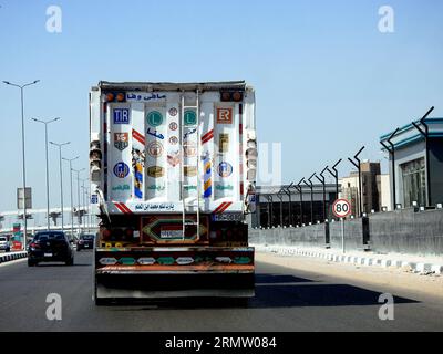 Le Caire, Egypte, août 21 2023 : camion à plateau grand véhicule avec un conteneur d'expédition en acier sur une autoroute en Egypte, expédition et service de livraison con Banque D'Images