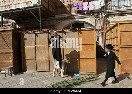 (141007) -- JÉRUSALEM, 7 octobre 2014 -- un juif ultra-orthodoxe construit une Soukka, une cabine rituelle utilisée pendant la fête juive de Soukcot dans un quartier religieux de Jérusalem le 7 octobre 2014. Les Juifs pratiquants construisent des structures temporaires pour le festival d'une semaine commémorant les 40 ans de voyage dans le désert après l'exode de l'esclavage en Égypte. Cette année, Sukkot commence jeudi. ) MOYEN-ORIENT-ISRAËL-SUKKOT-PRÉPARATION GilxCohenxMagen PUBLICATIONxNOTxINxCHN Jérusalem OCT 7 2014 à Ultra orthodoxe juif construit une Sukkah une cabine rituelle utilisée pendant la fête juive de Soukkot À un religieux N Banque D'Images