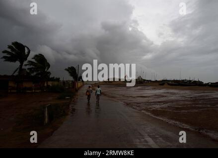 Deux villageois marchent à travers des vents forts sur la côte de la baie du Bengale à Gopalpur, dans l est de l état de l Inde de l Orissa, le 12 octobre 2014. Au moins six personnes ont été tuées dimanche lorsque le violent cyclone Hudhud a frappé la côte est de l'Inde avec des vents de près de 200 km/h, ont déclaré les responsables. INDE-GOPALPUR-TEMPÊTE Stringer PUBLICATIONxNOTxINxCHN deux villageois marchent à travers des vents forts DANS la baie de la côte du Bengale dans l'est de l'Inde du Sud État d'Orissa LE 12 2014 octobre AU moins six célébrités ont été TUÉES dimanche quand le cyclone sévère a frappé la côte est de l'Inde avec des vents de près de 200 km/h ont déclaré les responsables India Storm Stringer Banque D'Images