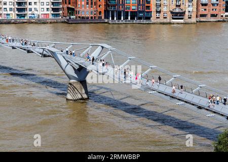 Piétons marchant à travers le Millennium Bridge sur la Tamise dans le centre de Londres, Royaume-Uni Banque D'Images