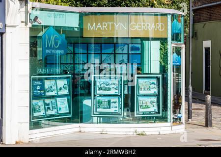 Une branche des agents immobiliers Martyn Gerrard avec un bureau à façade en verre de forme inhabituelle à Kentish Town, Londres, Royaume-Uni Banque D'Images