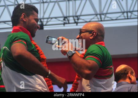 Le capitaine Mashrafe Bin Mortaza et l'entraîneur-chef Chandika Hathrusingha prennent un selfie pendant les joueurs de cricket nationaux du Bangladesh reçoivent un accueil chaleureux par le Banque D'Images