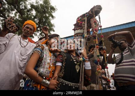 (141031) -- RAJASTHAN, 31 octobre 2014 -- les gens posent pour des photos avec un chameau décoré par l'artiste local Ashok Tak lors de l'exposition de décoration de chameaux à la Foire de chameaux à Pushkar au Rajasthan, Inde, le 31 octobre 2014. Des milliers de commerçants de bétail viennent à la foire annuelle traditionnelle des chameaux où le bétail, principalement des chameaux, est échangé. Cette foire est l'une des plus grandes foires de chameaux au monde. ) INDE-RAJASTHAN-PUSHKAR-CAMEL FAIR ZhengxHuansong PUBLICATIONxNOTxINxCHN Rajasthan OCT 31 2014 célébrités posent pour des photos avec un chameau décoré par l'artiste local Ashok Tak pendant le Camel Decoration Show in T. Banque D'Images