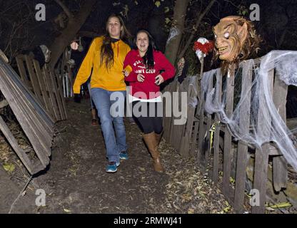 MONTRÉAL, le 30 octobre 2014 -- des filles effrayées réagissent dans les bois hantés d'Halloween, dans la réserve Mohawk de Kahnawake, près de Montréal, Canada, le 30 octobre 2014. Plus de 10 bénévoles portant des costumes effrayants effrayent et divertissent les visiteurs pendant la saison d'Halloween ici. L'activité de deux jours recueille également de la nourriture et des dons pour la banque alimentaire locale. CANADA-MONTRÉAL-HALLOWEEN AndrewxSoong PUBLICATIONxNOTxINxCHN Montréal OCT 30 2014 des filles effrayées réagissent dans les bois hantés d'Halloween SUR la réserve Mohawk de Kahnawake près de Montréal Canada OCT 30 2014 plus de 10 bénévoles portant de l'effraie Banque D'Images