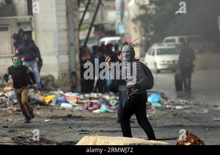 (141031) -- RAMALLAH, le 31 octobre 2014 -- Un manifestant palestinien lance des pierres sur des soldats israéliens lors d'affrontements au poste de contrôle de Qalandiya près de la ville de Ramallah en Cisjordanie le 31 octobre 2014. Des affrontements ont éclaté vendredi entre manifestants palestiniens et soldats israéliens dans plusieurs villes de Cisjordanie.) MIDEAST-RAMALLAH-AFFRONTEMENTS FadixArouri PUBLICATIONxNOTxINxCHN Ramallah OCT 31 2014 un hurle PALESTINIEN pierres contre des soldats israéliens lors d'affrontements AU poste de contrôle de Qalandiya près de la ville de Ramallah en CISJORDANIE LE 31 2014 octobre des affrontements ont éclaté vendredi entre manifestants PALESTINIENS et Israéliens Banque D'Images