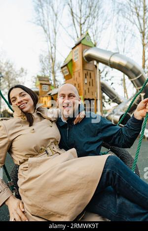 Heureux couple souriant passer du temps sur une aire de jeux Banque D'Images