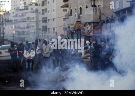 (141106) -- JÉRUSALEM, 6 novembre 2014 -- la fumée monte alors que des jeunes Palestiniens affrontent les forces de sécurité israéliennes dans le camp de réfugiés palestiniens de Shuafat, Jérusalem-est, le 6 novembre 2014. Le Premier ministre israélien Benjamin Netanyahu a rassuré jeudi le roi Abdallah II de Jordanie qu’Israël n’a pas l’intention de changer le statu quo dans la mosquée al-Aqsa et son complexe à Jérusalem-est, ont déclaré des responsables et des médias locaux. De nouveaux affrontements entre Palestiniens jetant des pierres et police ont éclaté mercredi après qu'un groupe de militants d'extrême droite ait tenté de mener une veillée de prière sur le site. MIDEAST-EAST JE Banque D'Images