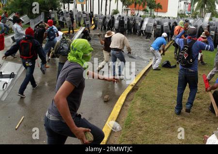 Des manifestants s’affrontent avec des policiers anti-émeutes à Acapulco, dans l’État de Guerrero, au Mexique, le 10 novembre 2014. Un groupe de 300 manifestants, ainsi que les parents des 43 élèves disparus de l'école rurale normale d'Ayotzinapa, ont affronté la police anti-émeute tout en exigeant le retour en toute sécurité des élèves disparus, selon la presse locale. (rtg) (sp) MEXICO-GUERRERO-SOCIETY-PROTEST JavierxVerdin PUBLICATIONxNOTxINxCHN un manifestant affrontement avec des policiers des émeutes à Acapulco, Mexique État de Guerrero Mexique LE 10 2014 novembre un groupe de 300 manifestants accompagnés des parents des 43 élèves disparus de l'école rurale normale de S Banque D'Images